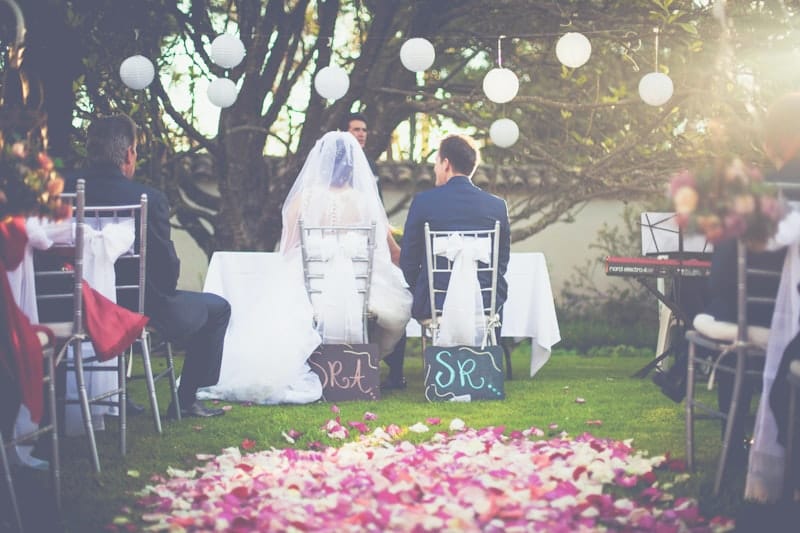 Bride and groom at an outdoor wedding ceremony in Colombia with rose petal aisle and paper lanterns