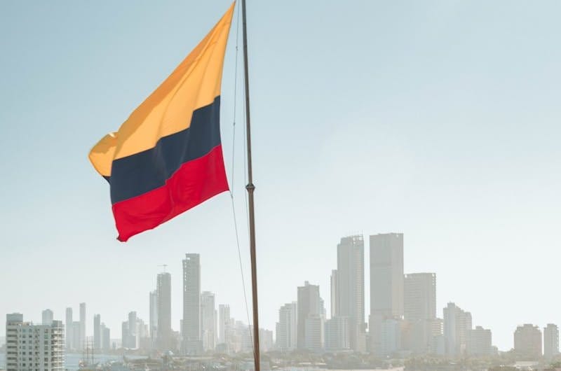 Colombian flag waving with Cartagena city skyline in the background