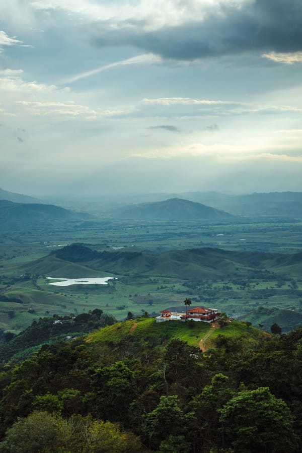 Vista aérea de paisaje rural en Colombia con finca entre montañas verdes