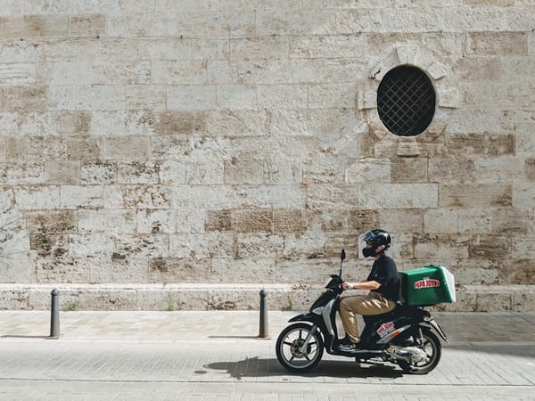 Delivery scooter rider in a city street, representing Colombia's thriving food delivery app scene